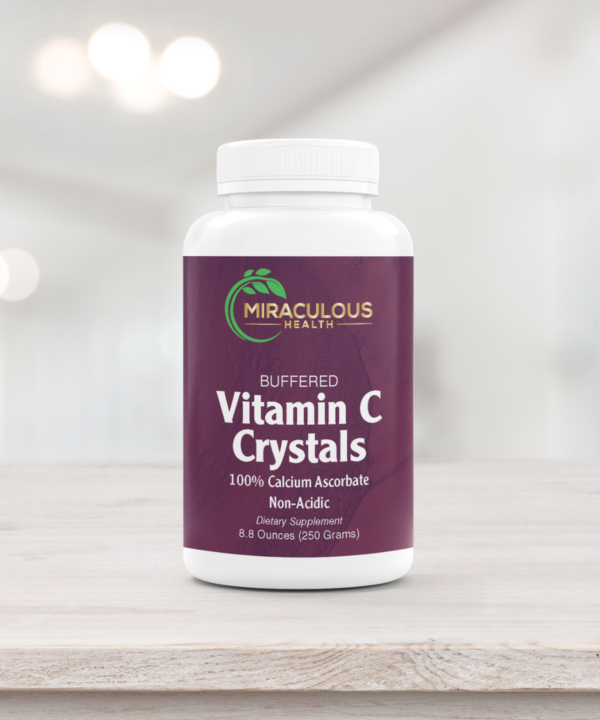 Miraculous Health Buffered Vitamin C Crystals 8.8-ounce bottle on a light wooden surface. The bottle features the Miraculous Health logo with text highlighting 100% Calcium Ascorbate, a non-acidic dietary supplement. Miraculous Health offers the finest vitamins and supplements to fuel your health and wellness journey. Visit MiraculousHealth.org to learn more!