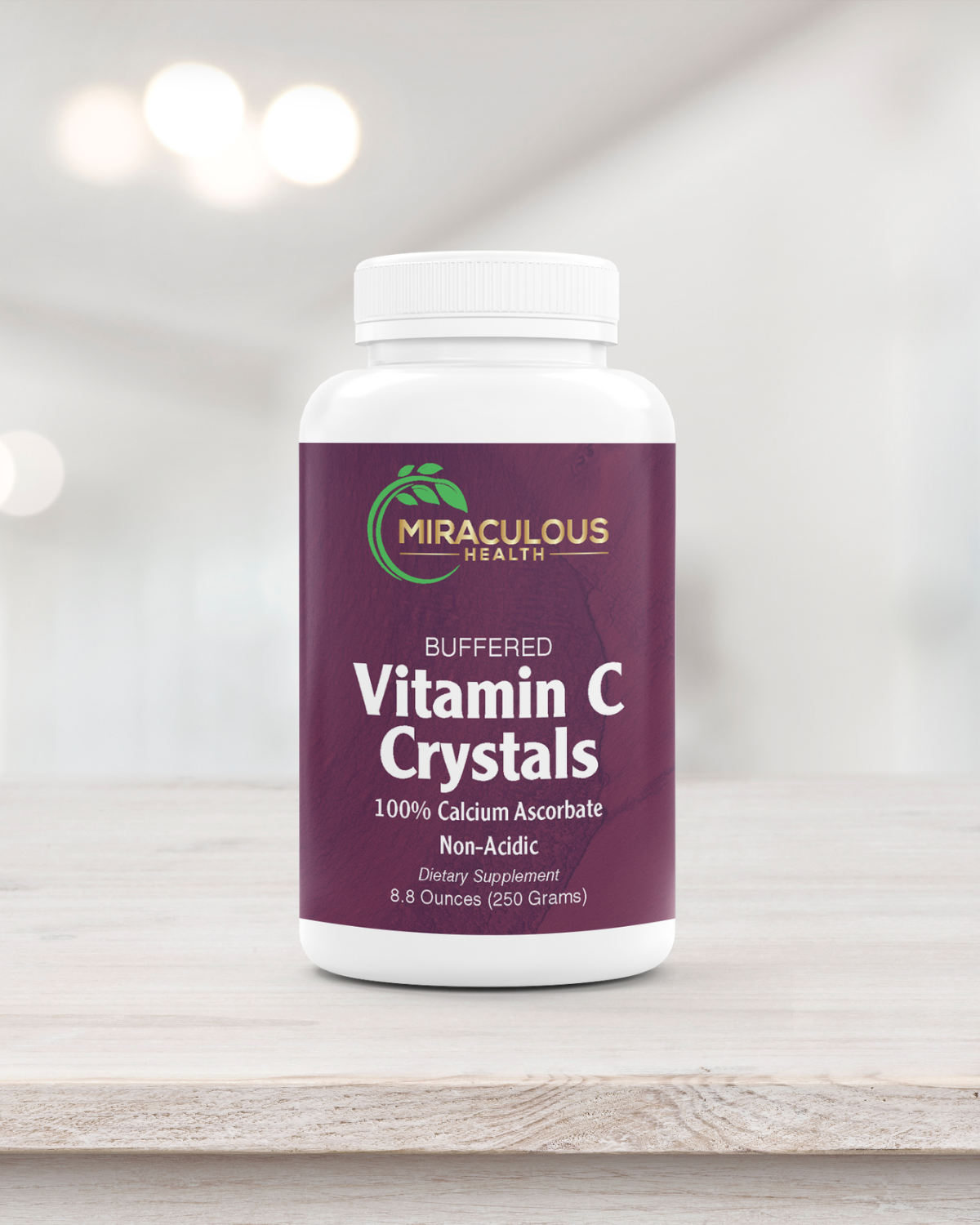 Miraculous Health Buffered Vitamin C Crystals 8.8-ounce bottle on a light wooden surface. The bottle features the Miraculous Health logo with text highlighting 100% Calcium Ascorbate, a non-acidic dietary supplement. Miraculous Health offers the finest vitamins and supplements to fuel your health and wellness journey. Visit MiraculousHealth.org to learn more!